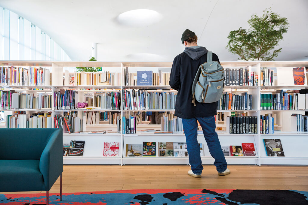 A person looking for books in a library.