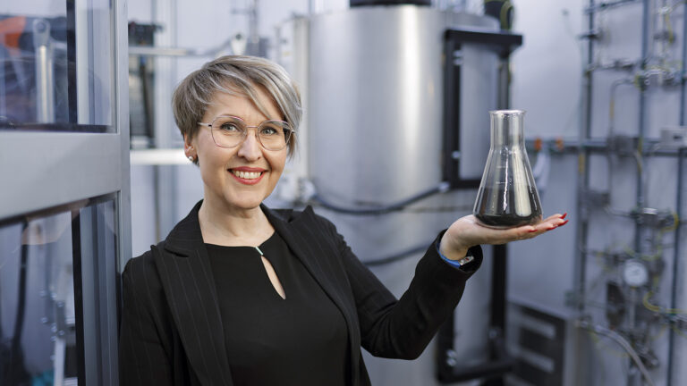 Hycamite TCD Technologies’ CEO Laura Rahikka holding a flat-bottomed flask.