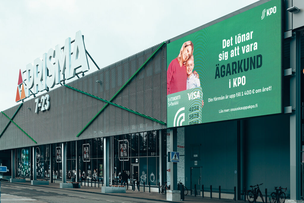 Prisma Liisanlehto pictured from the outside. There is a large led screen showing an advertisement on the wall.