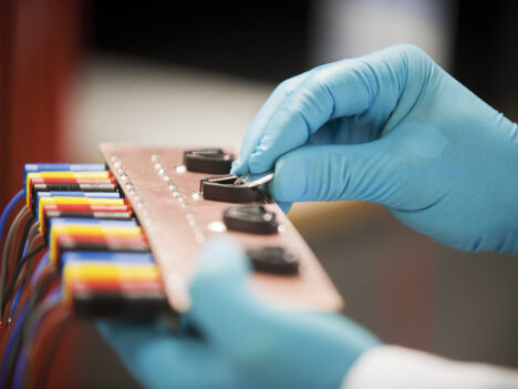 Battery cells held by a person with gloves on.