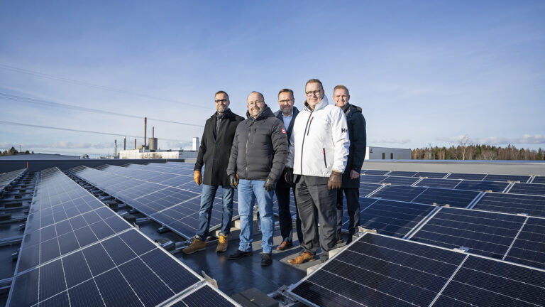 The management of Leinolat Group standing on the roof of the Kilkanen factory. The roof is filled with solar panels.