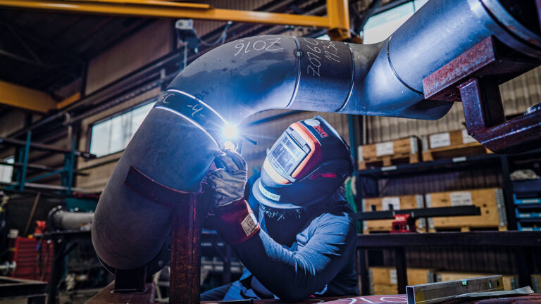 A person welding a pipe.