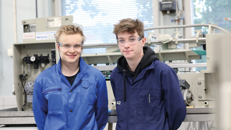 Process operator students Jere Puikko and Jesse Peltola in a laboratory with safety equipment on.