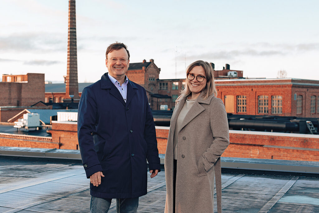 The University of Vaasa's Dean of the School of Technology and Innovations Raine Hermans and VEBIC's Director Suvi Karirinne. They are standing on a rooftop in the university campus area.