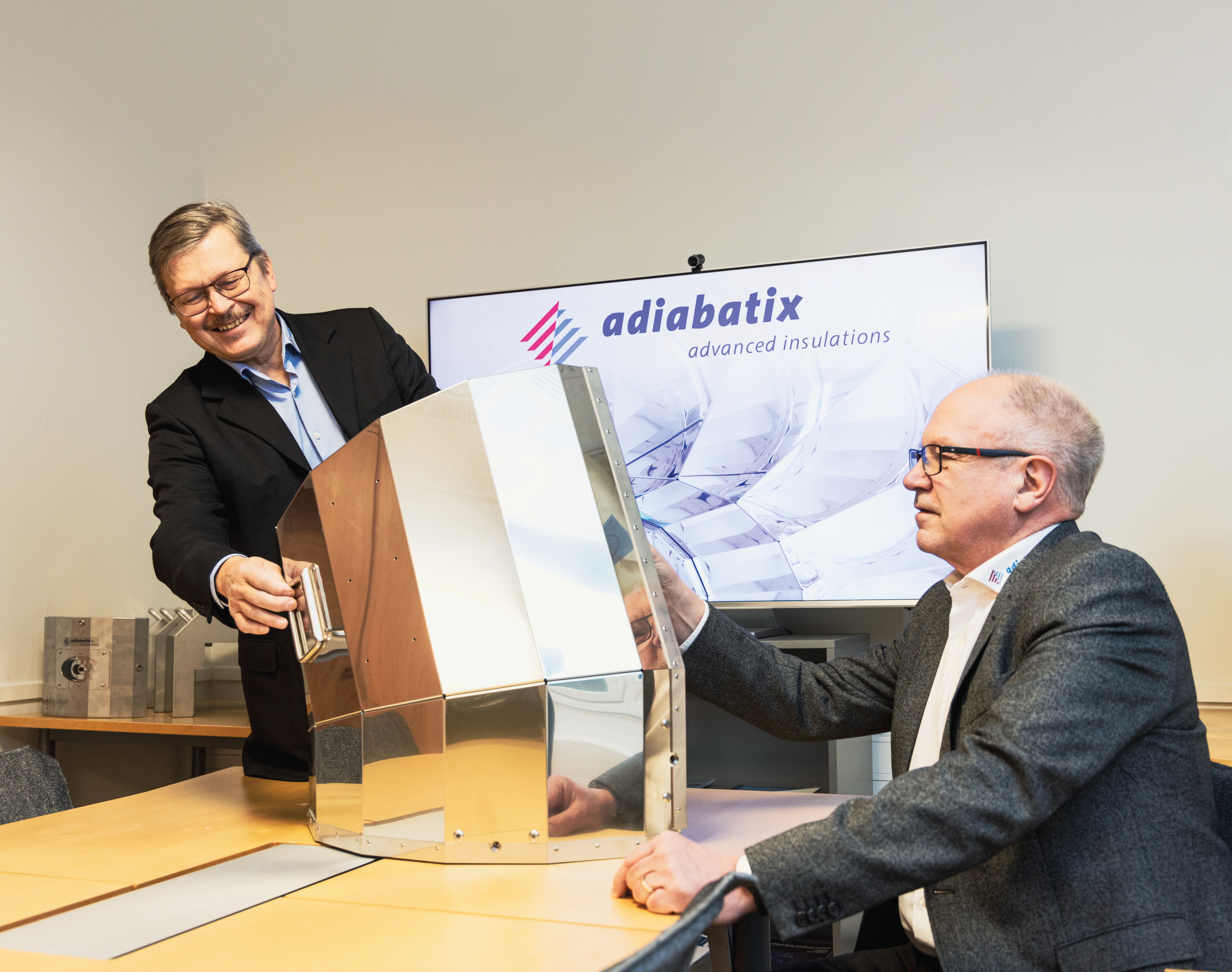 Arto Wainio and Jerker Kullberg showcasing Adiabatix's Reflective Metallic Insulation solution in an office.