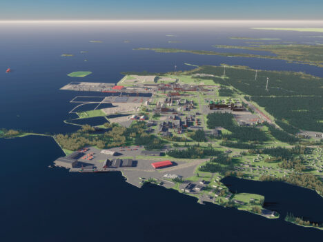 The Kokkola Industrial Park pictured from high above by the sea. There are multiple buildings and a forest.