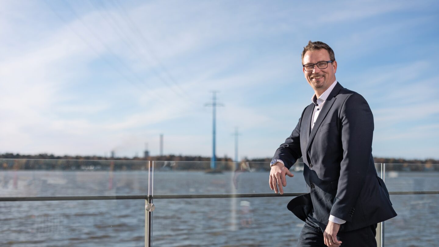 Mats Söderlund by the sea with power cables going over the water.