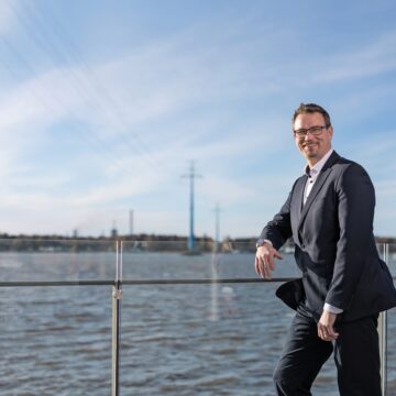 Mats Söderlund by the sea with power cables going over the water.
