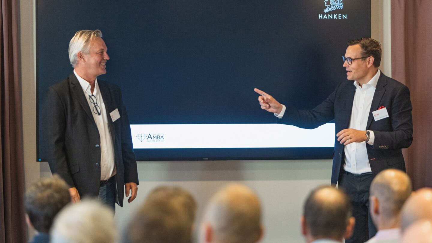 Kai Kamila and Marc Hinnenberg giving a presentation. There is a screen behind them with a Hanken logo on it.
