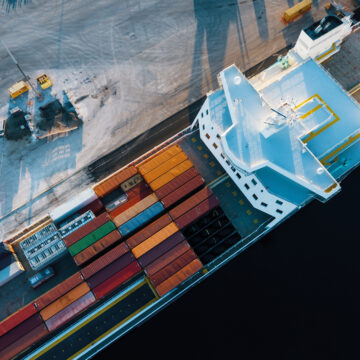 A large marine vessel loaded with containers pictured from above.