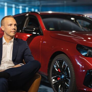 Henrik Pohjus sitting on a chair in front of a car.